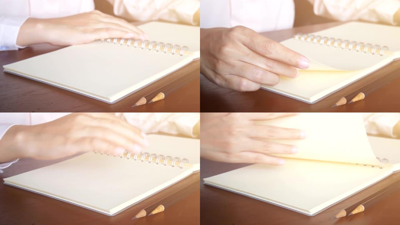4k环路。手指握住纸张的一角，然后将页面翻转过来。空白页面的书。手指选择性聚焦，软过滤器