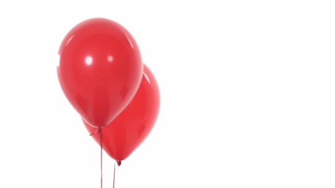 两个红色飞行气球的特写。对象从左到右移动。孤立，在白色背景上。复制空间