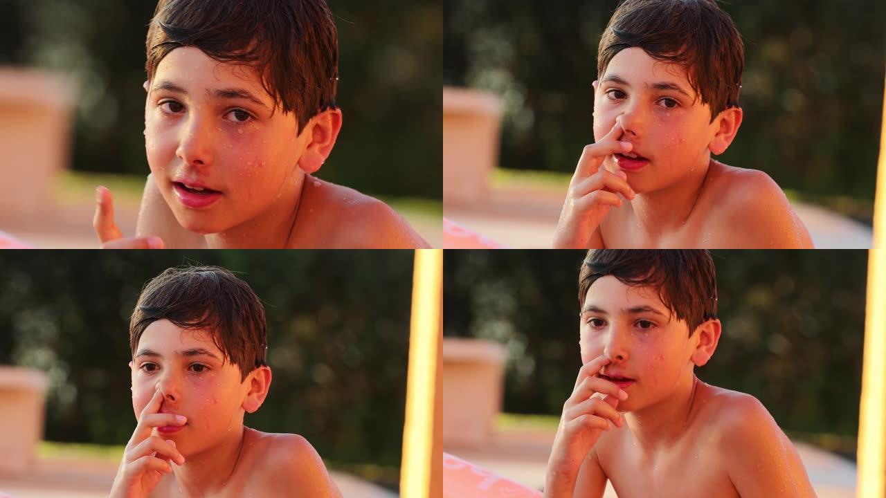 小男孩手指在游泳池旁鼻涕。儿童把手指放在鼻子里