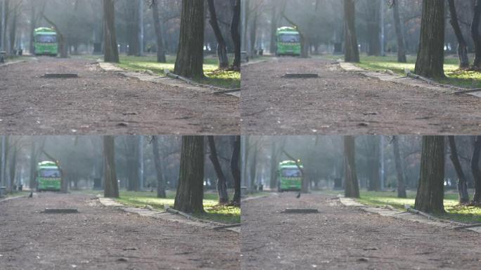 清扫车早上在秋季公园清理小巷。
