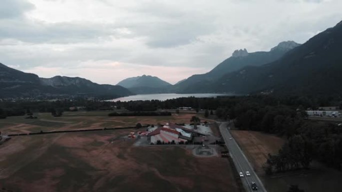从鸟瞰图看滑翔伞基地。无人机在悬挂式滑翔中心周围飞行。法国阿讷西湖和山脉