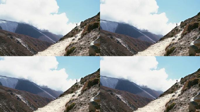 在腾博什附近的珠穆朗玛峰大本营徒步路线上，云层背景上的4k徒步旅行者剪影站在越过Imja Khola