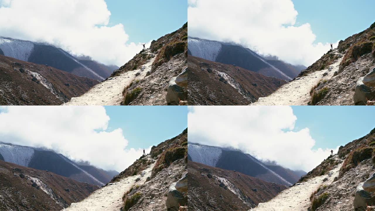 在腾博什附近的珠穆朗玛峰大本营徒步路线上，云层背景上的4k徒步旅行者剪影站在越过Imja Khola