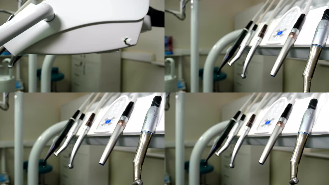 牙科诊所: 控制台上有牙科医疗设备的房间。将黑色手套放在牙科仪表板上的移动钻头组。特写。牙科护理工具