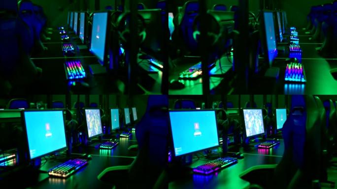带有显示器和键盘的电脑桌在网络俱乐部的黑暗房间里排成一排。程序员的工作场所，显示器用蓝屏燃烧。