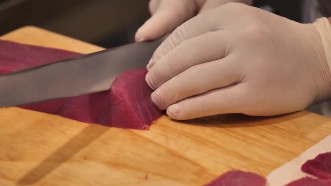 A厨师slicing tuna fillet