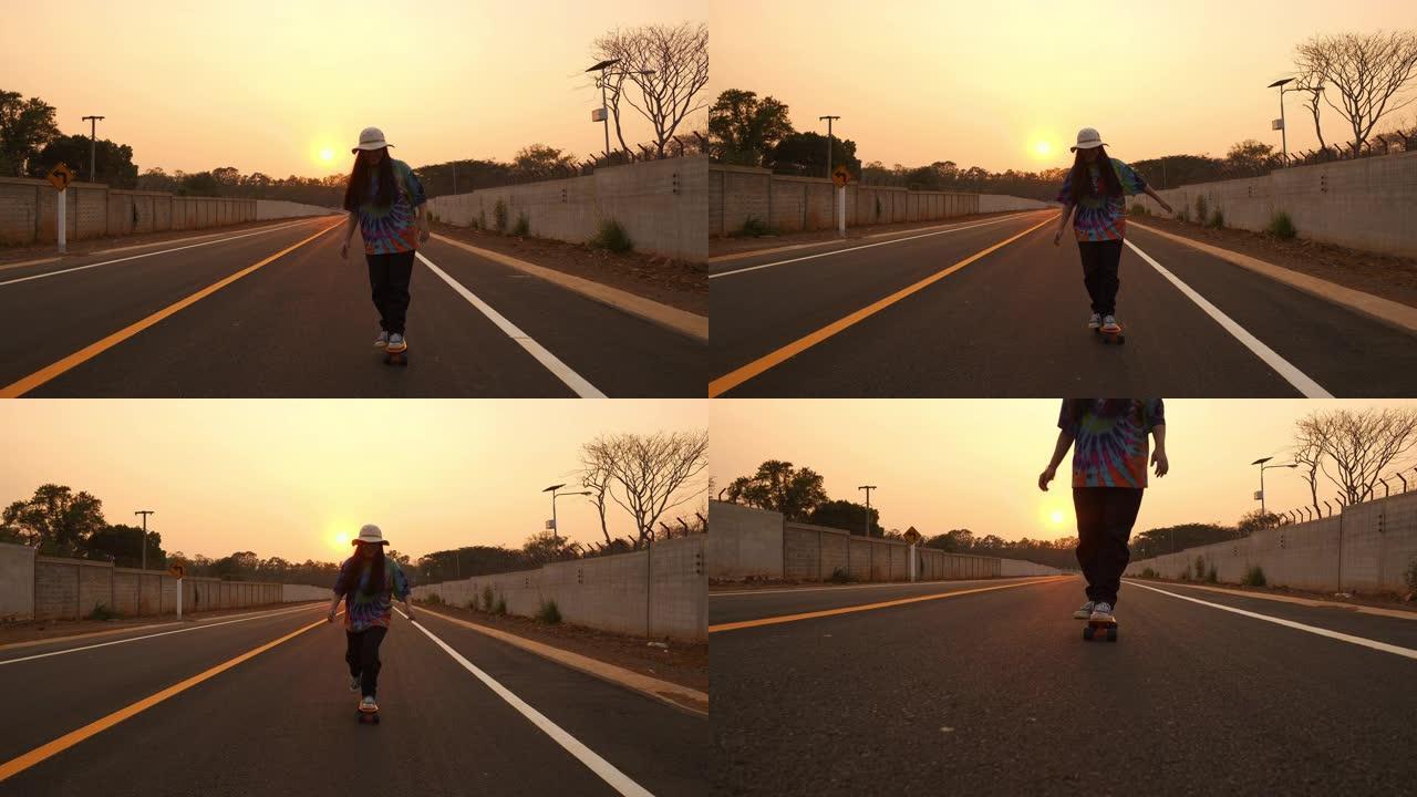 日落时的年轻女子滑板