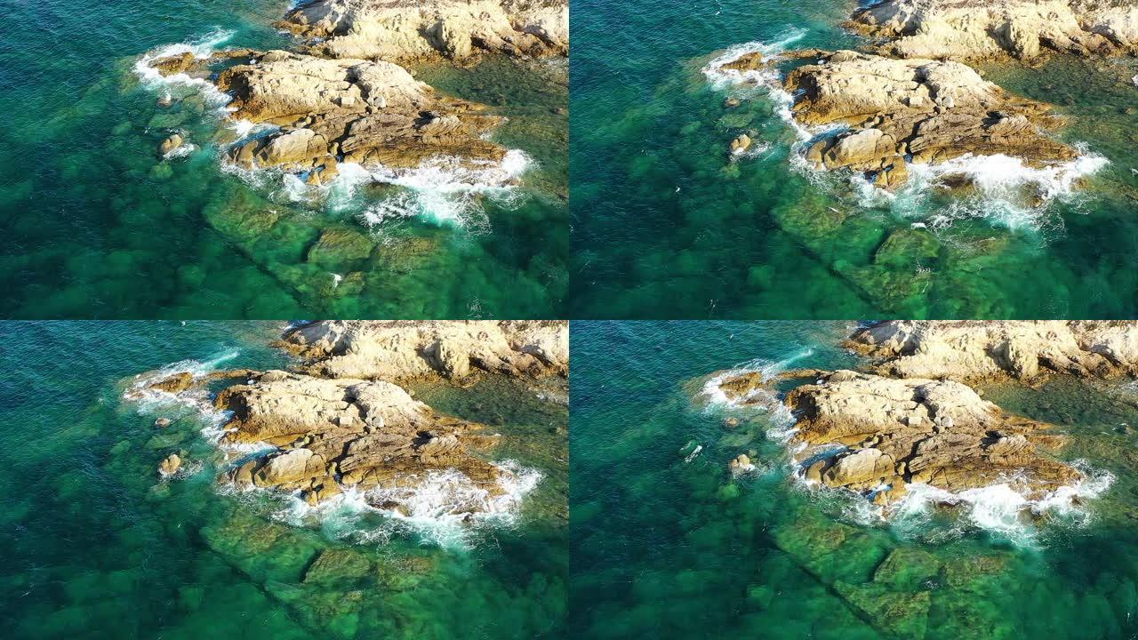 地中海的海浪，绿松石色，撞击在法国科西嘉岛的岩石上