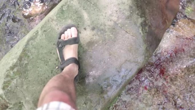 自然界中的Vlogging。一个独自旅行者在水中行走的视点。山河。