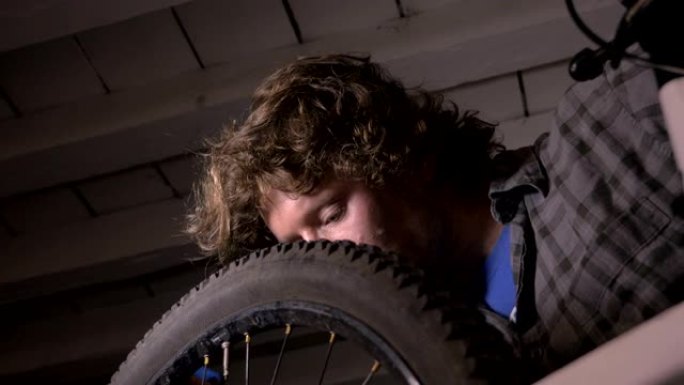 低角度的千禧人自行车技工在工作的自行车车轮