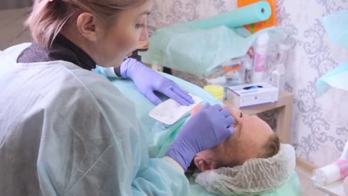 50岁的中年妇女正在由医生美容师向面部注射透明质酸。美容程序