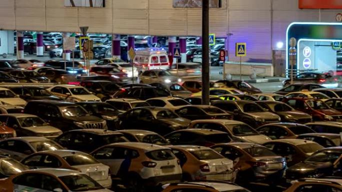 在一个销售高涨的夜晚，购物中心停车场的汽车时间流逝