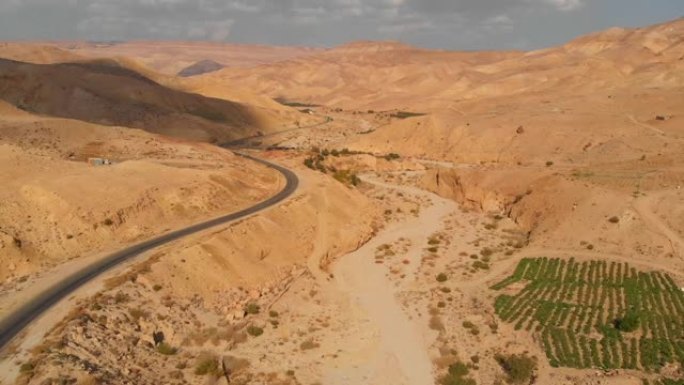 沙漠山丘上的高速公路，用无人机拍摄。空旷的高速公路，美丽的自然景观。中东沙漠中的国王公路。