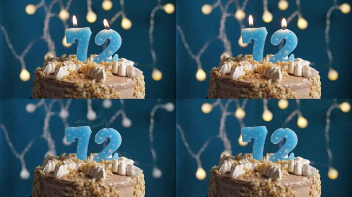 蓝色背景上有72号蜡烛的生日蛋糕。蜡烛吹灭了。慢动作和特写视图