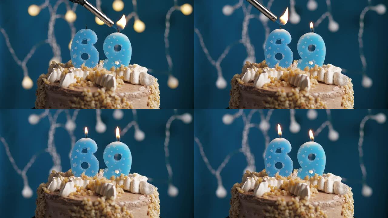 蓝色背景上有69号蜡烛的生日蛋糕。蜡烛着火了。慢动作和特写视图