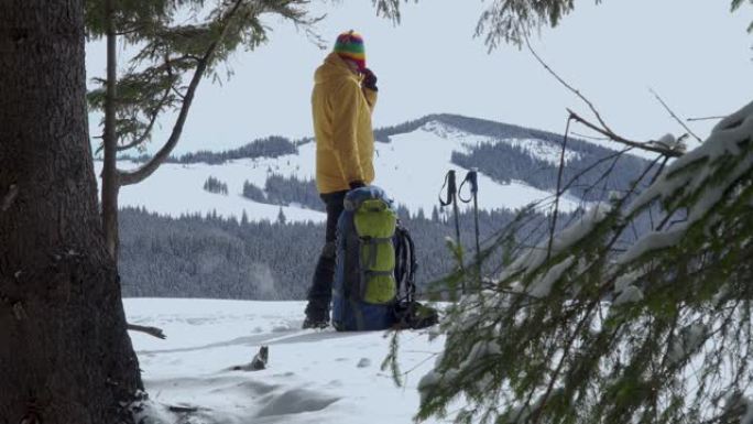 一个背着背包的男人冬天在山里旅行
