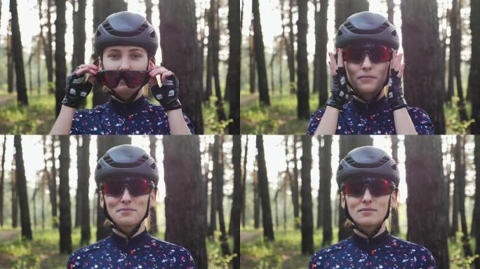 年轻漂亮的女孩戴着头盔和蓝色球衣戴上自行车眼镜。公路自行车概念。慢动作