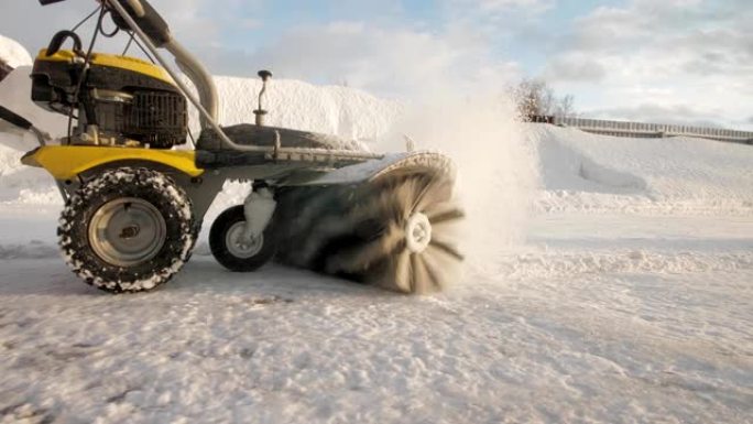 男子在冬天用扫地机清理院子里的雪