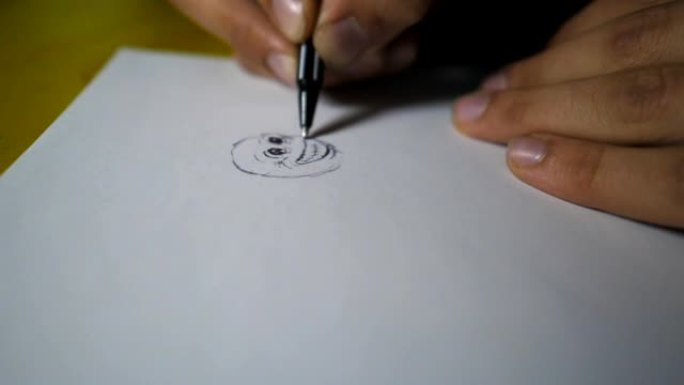 男性的手拿着圆珠笔，在白纸上画笑脸。才华横溢的艺术家手臂的特写在素描本中描绘了美丽的小图像。艺术和创