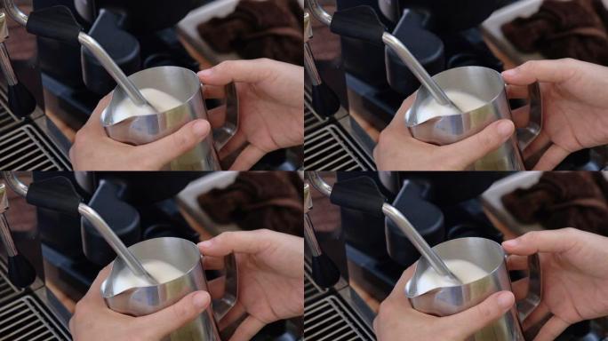 咖啡师在喝拿铁艺术之前先在水罐中蒸牛奶。