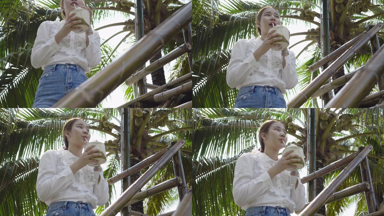 亚洲女孩在大自然中喝椰子水