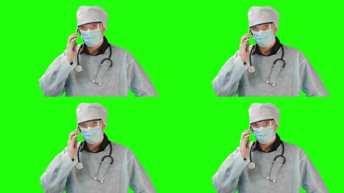 年轻的医生戴着医用口罩和防护服在电话里说话。在Chrome Key的背景上拍摄。铬凯高品质