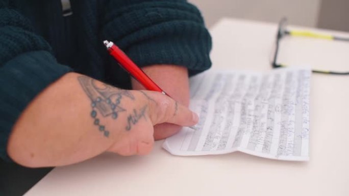 一个手上有解剖过程的人在纸上写字。