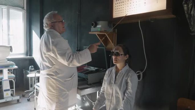 用验光仪和视力表进行视力测试。年轻女子在眼科医生那里检查眼睛。白领工人。活跃的老年人在他们的工作场所
