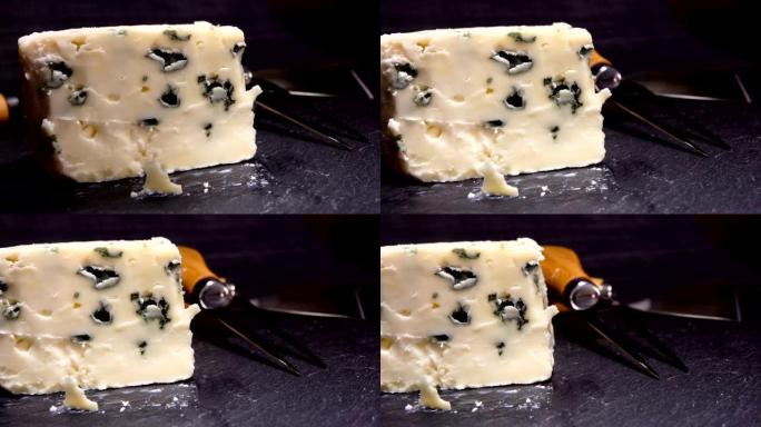 从黑石板上切下并提起一块蓝模奶酪