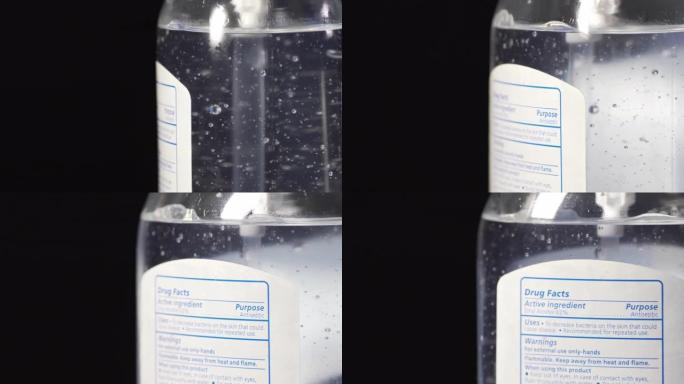 在深黑色背景下用酒精和芦荟消毒的凝胶洗手液上特写移动旋转标签防止COVID传染性非典型肺炎nCoV 