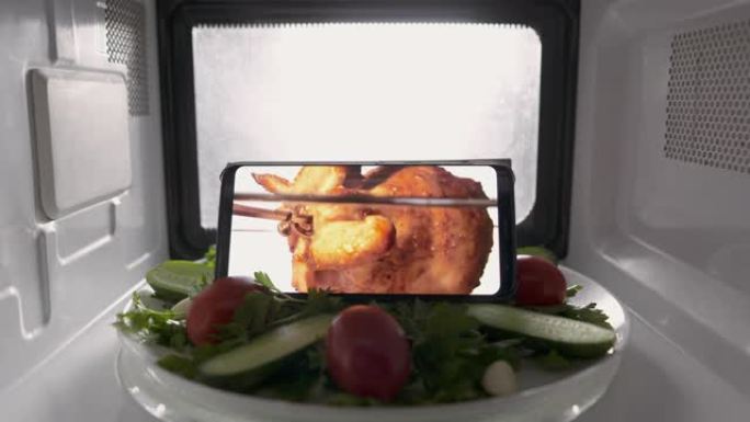 用微波炉在屏幕上播放沙拉和带有食物素材的手机。