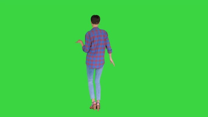 穿着休闲衬衫的女人在绿色屏幕上跳舞，色键