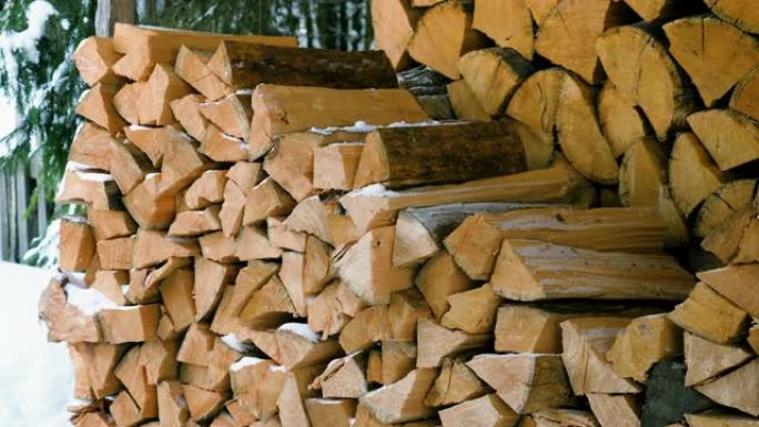 在院子里堆放在一个大原木木桩上的切碎和锯开的树干的特写镜头。为壁炉和炉子准备的柴火。4K