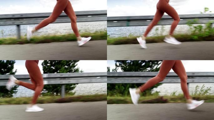 在湖附近的乡间小路上奔跑时，女性腿的侧面跟踪镜头