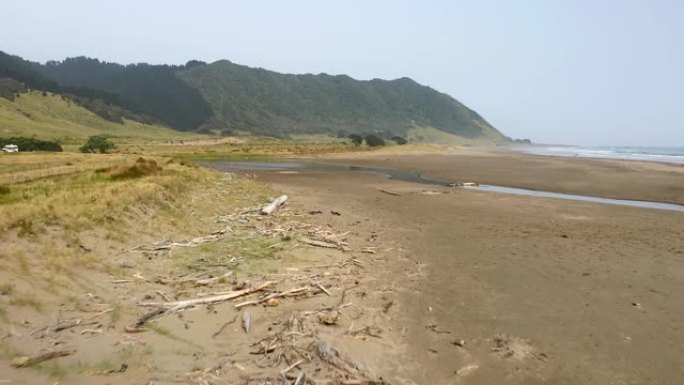 空中: 在新西兰北岛东角的海滩上低空飞过高潮线的浮木