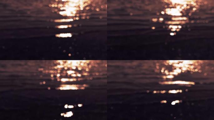 在阳光照射下散焦的河流波纹，在其表面闪耀反射。日落时模糊的金色水面，背景。抽象闪烁的大海、河流或海洋