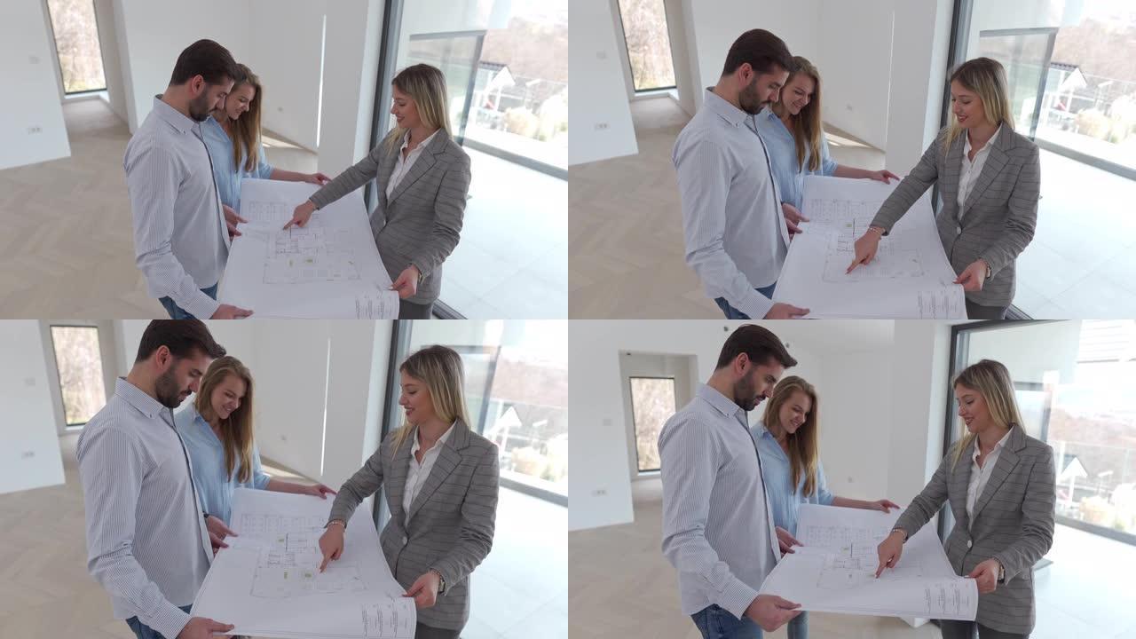 一位年轻的建筑师向一对年轻夫妇展示了他们新房子的蓝图。