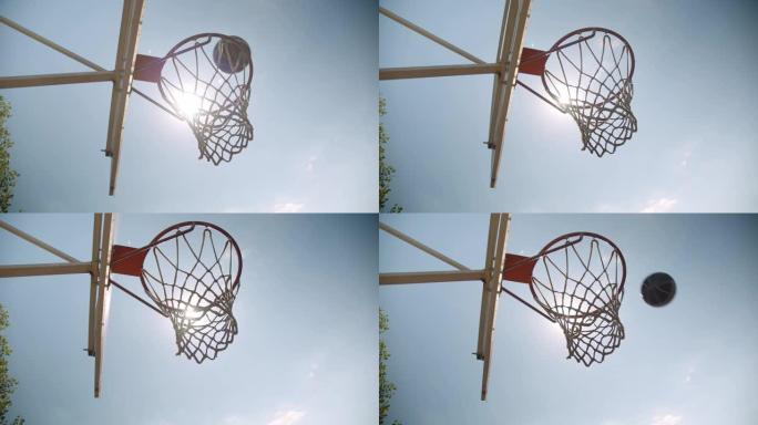 在明亮的阳光下，篮球球在球场上被扔进篮筐的特写肖像