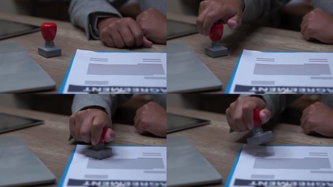 男性双手签署和盖章合同