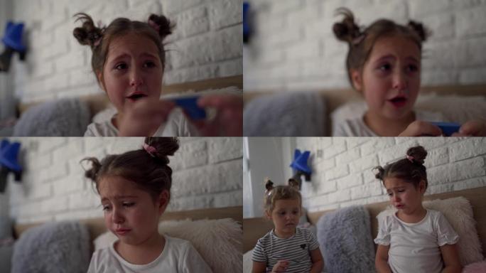 幼儿在与玩具积木的兄弟姐妹玩耍时哭泣