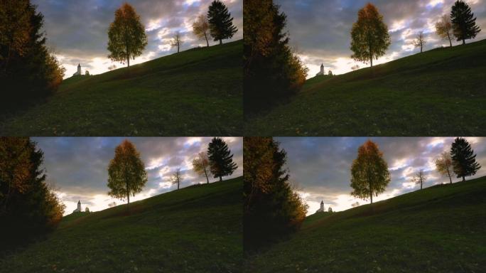 摄影师在日落时在田野里拍摄孤独的树的照片。美丽的斯洛文尼亚景观
