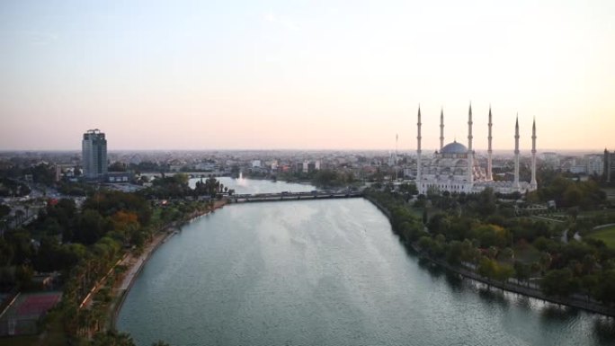 土耳其阿达纳的萨班奇中央清真寺、老钟楼和石桥。塞罕河前有清真寺尖塔的阿达纳城。