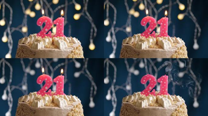 蓝色背景上有21号粉色蜡烛的生日蛋糕。蜡烛吹灭了。慢动作和特写视图