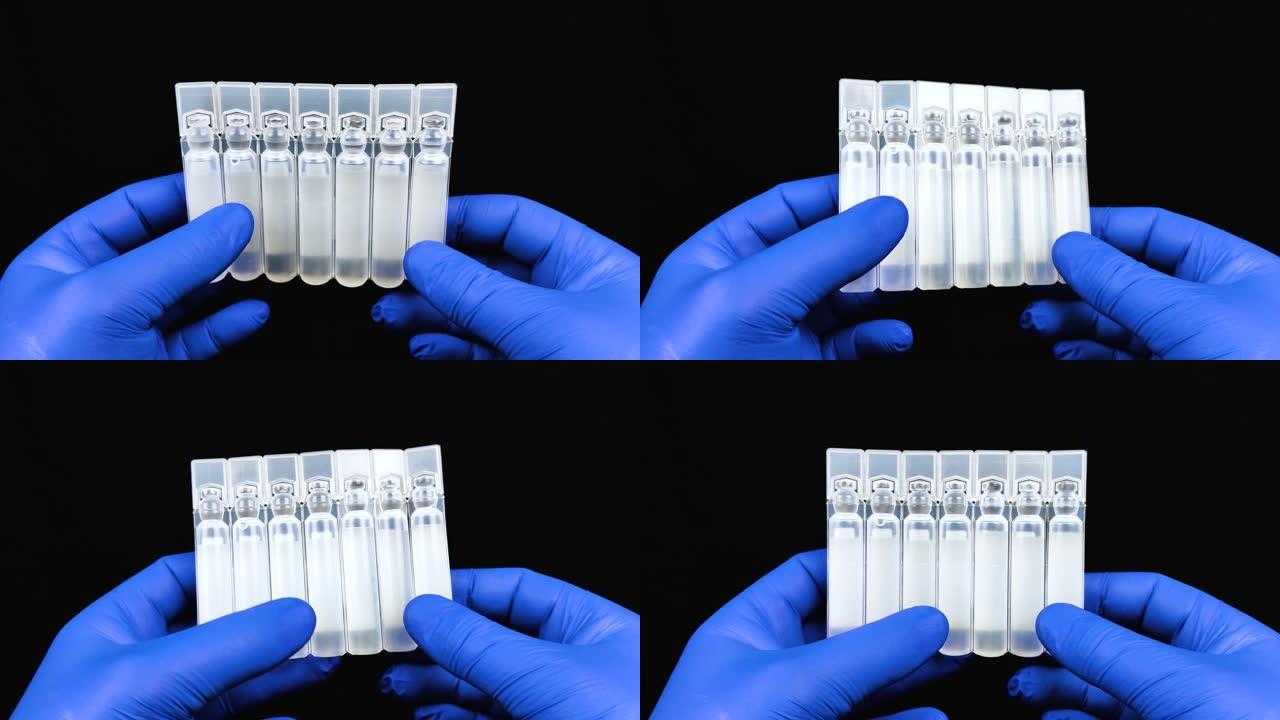 塑料安瓿与药物或疫苗特写。戴着蓝色手套的医生检查药物。宏视频。现代医学概念