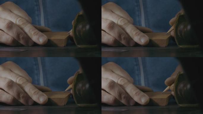 用铅笔标记木制细节的男性手的特写镜头，用于制作木制胡须梳。手工工匠制作木梳。电影4k视频
