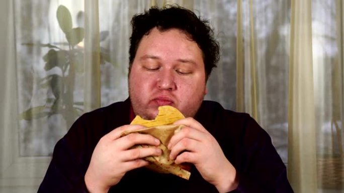 年轻人咬三明治。胖子吃快餐。非常饿的家伙。