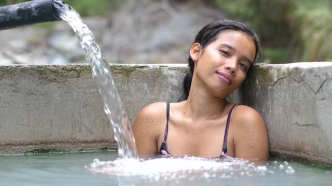周末，年轻女子在天然温泉中减轻压力。