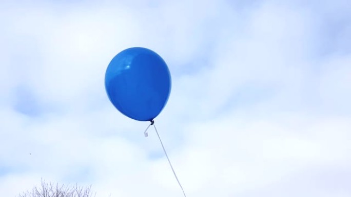 一个蓝色的气球在一根绳子上，在风中飞行的蓝天上，有云彩，4k视频