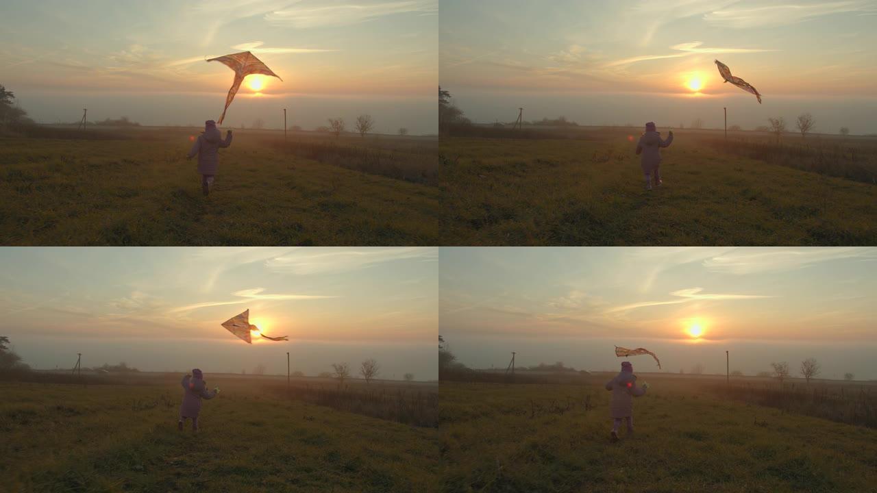 一个小女孩在日落时放风筝。雾上方的太阳。4k超高清