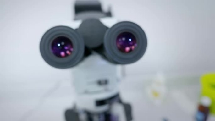 女科学家寻找显微镜目镜。通过显微镜观察的女科学家肖像